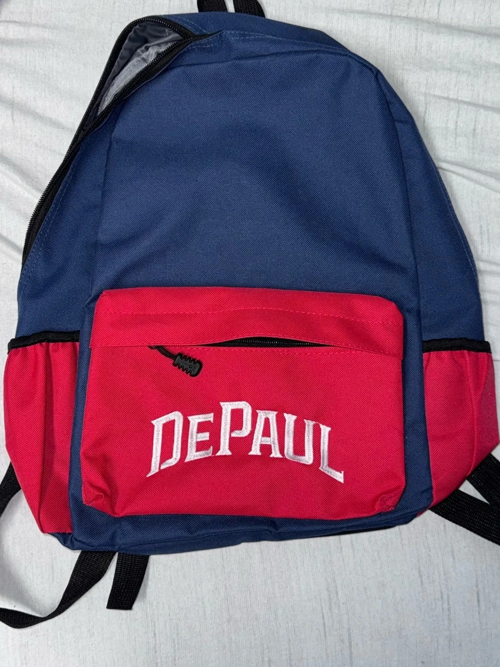 DePaul University navy blue and red backpack with white 'DEPAUL’ embroidered in